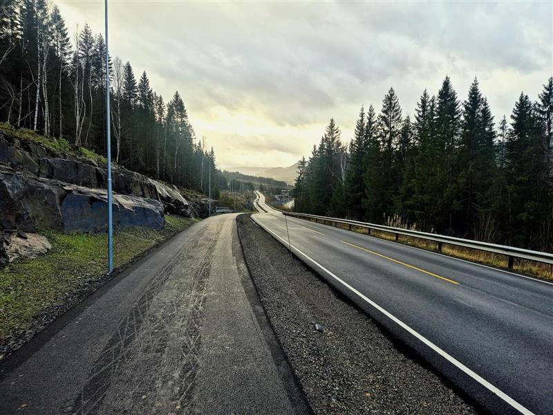 Asfaltert vei og gang- og sykkelvei gjennom skogsterreng